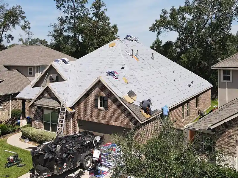 Crew installing new shingles on a home